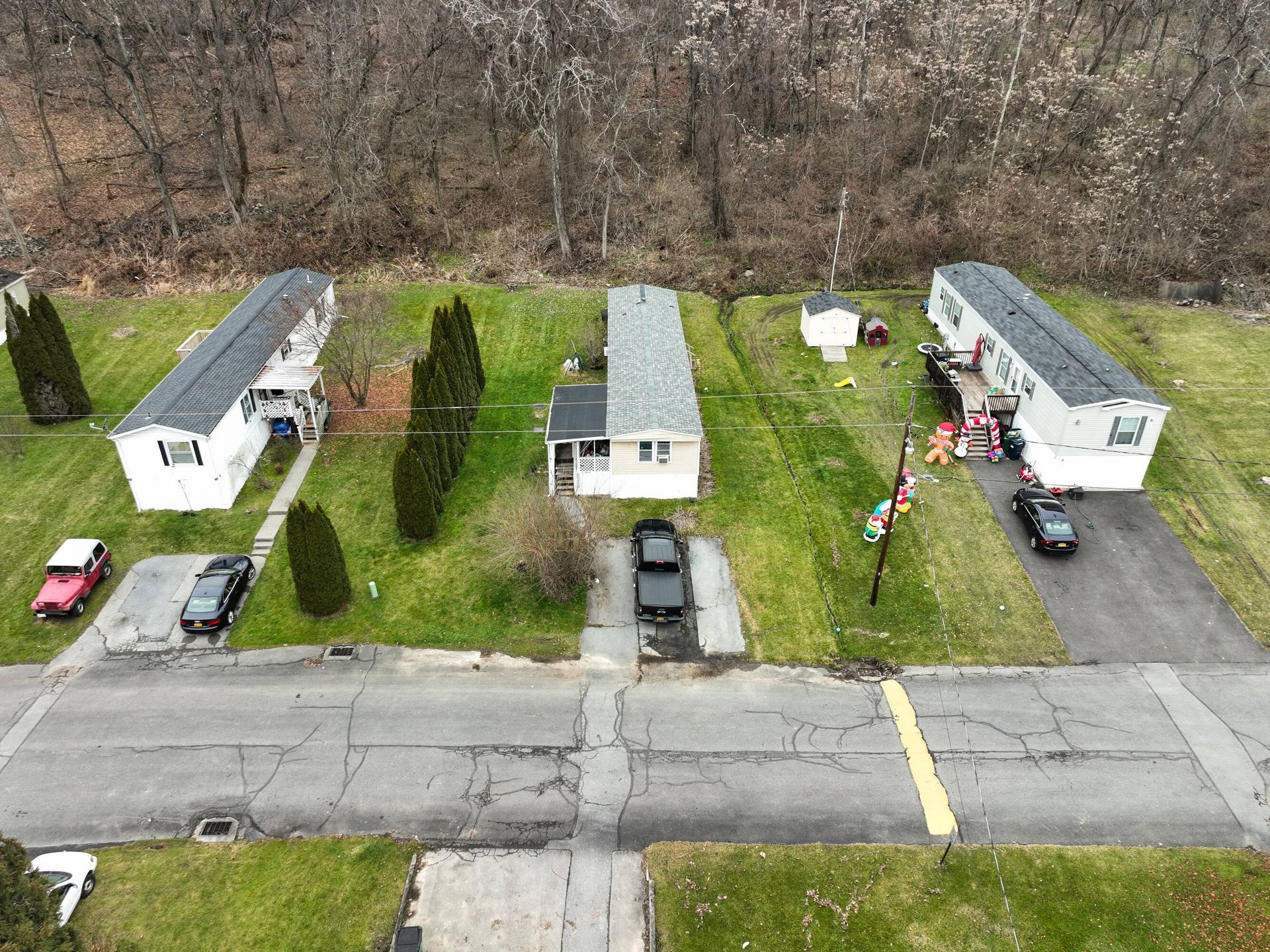 An aerial view of a residential area with a lot of houses and cars parked on the side of the road.