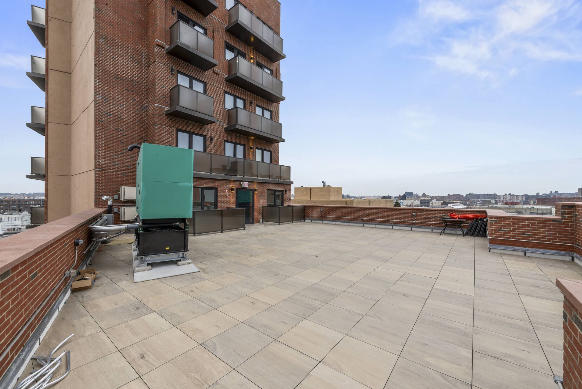 A large brick building with a rooftop patio in front of it