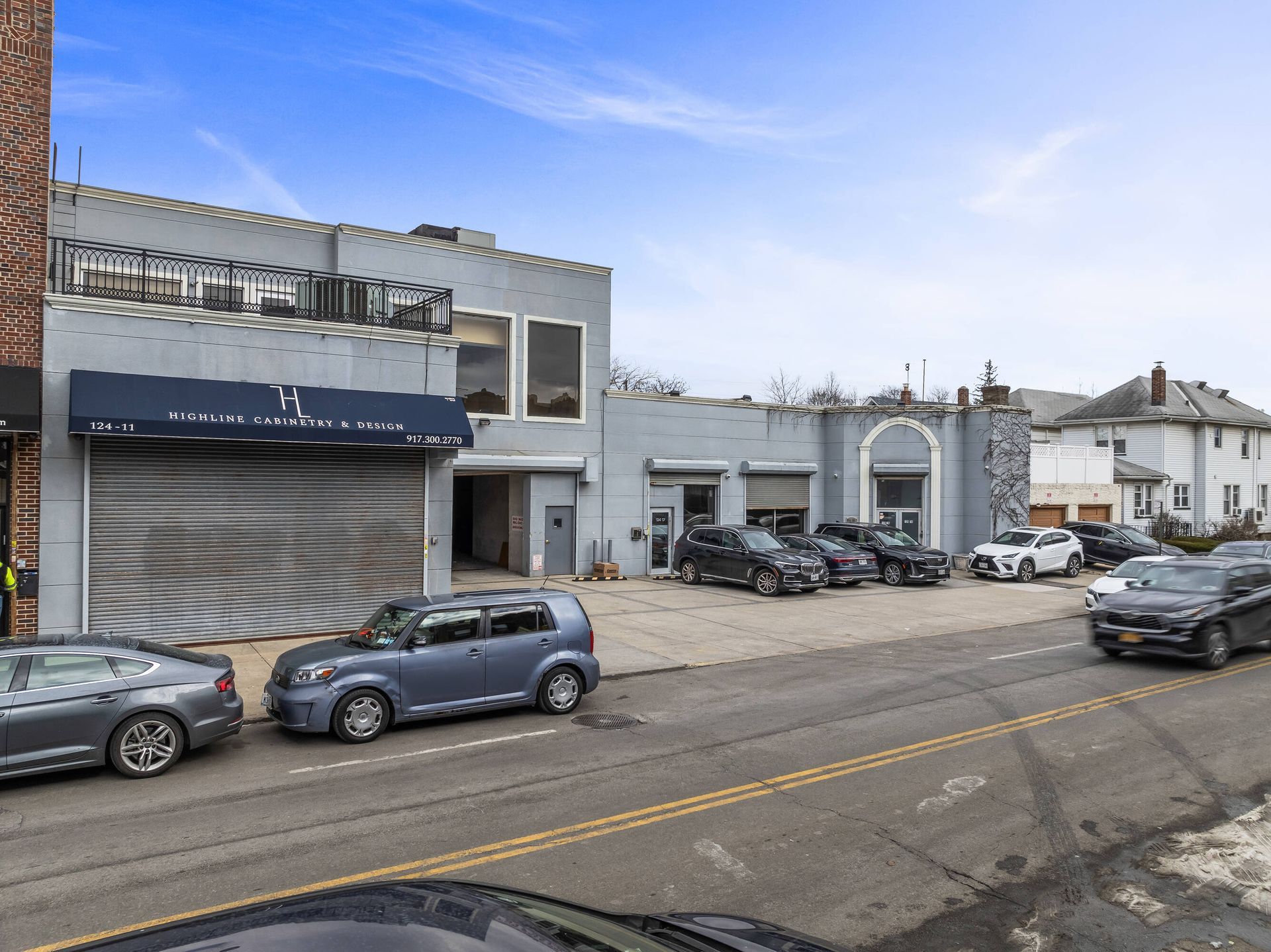 A row of cars are parked in front of a building.