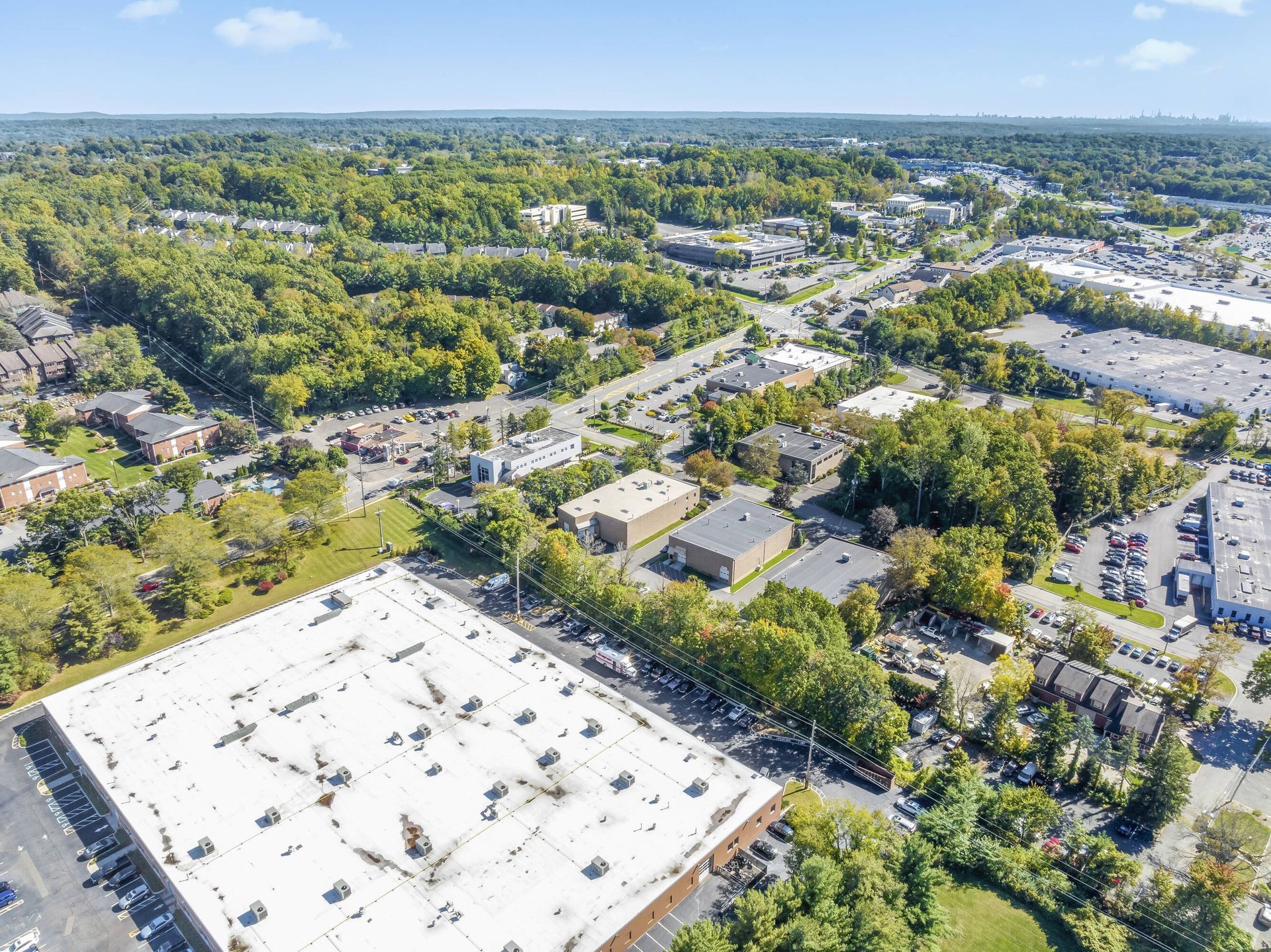 An aerial view of a city with a large white building in the middle of it.