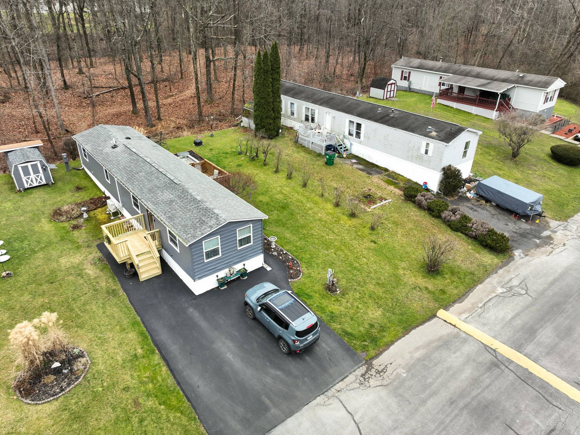 An aerial view of a mobile home park with a car parked in the driveway.