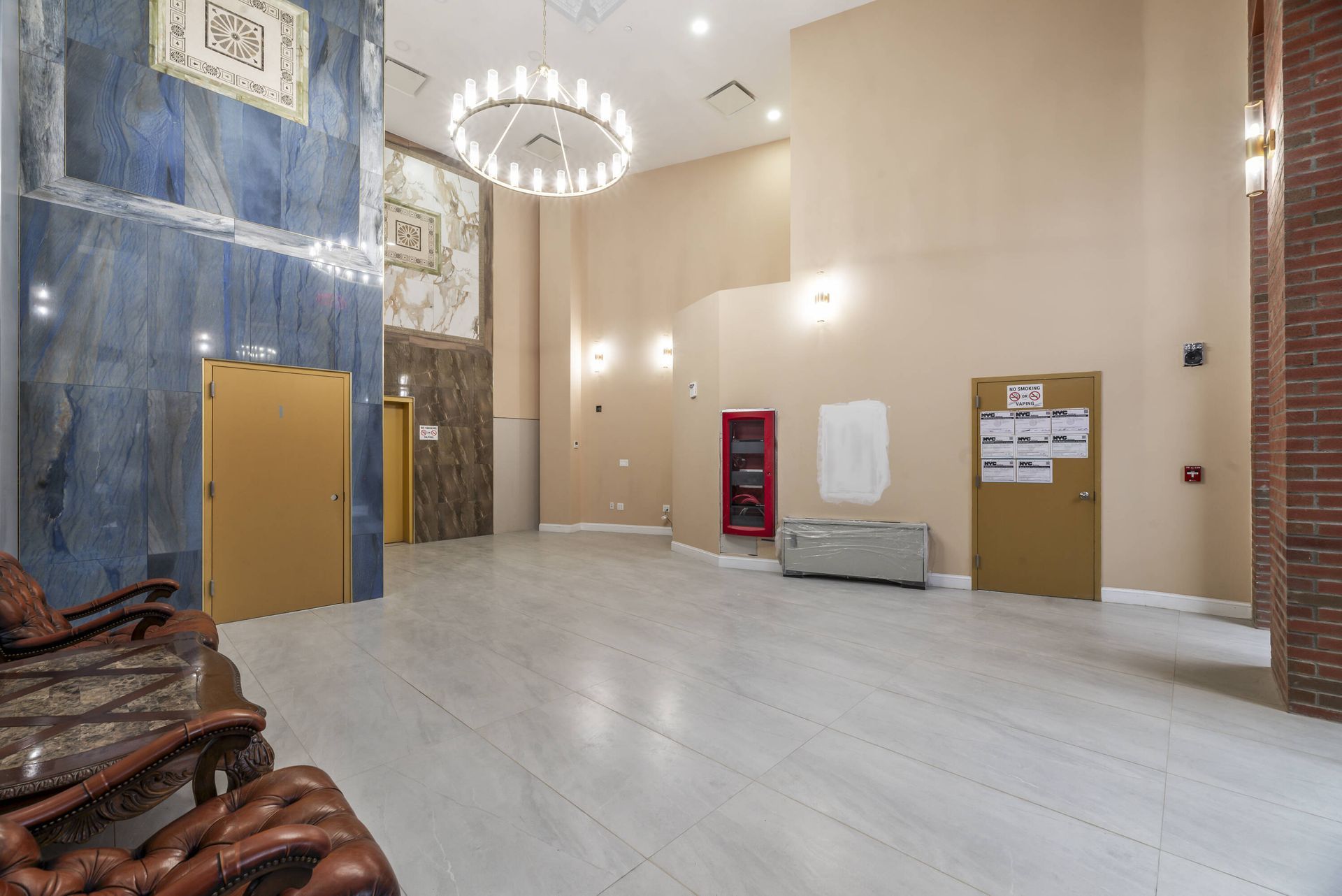 A large empty lobby with a chandelier hanging from the ceiling.