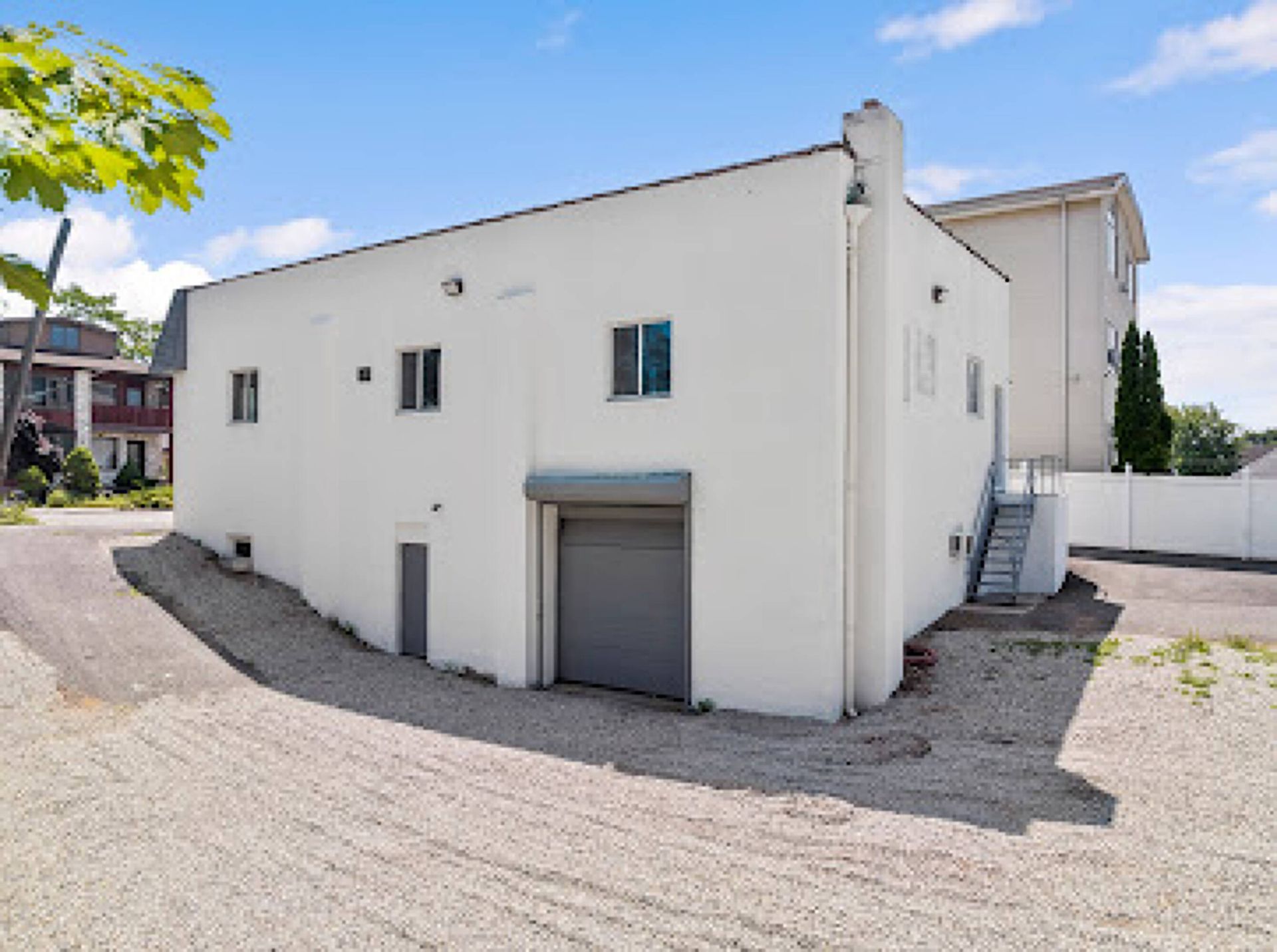A large white building with a garage and stairs