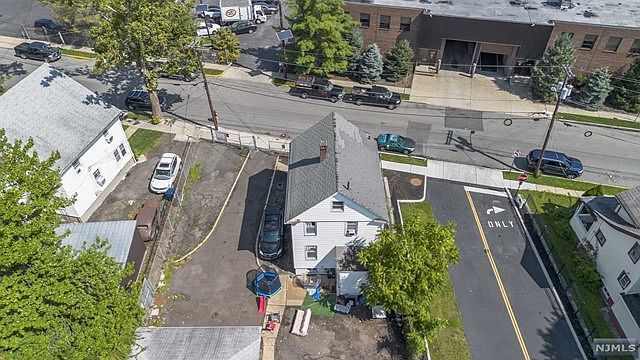 An aerial view of a house and a parking lot in a city.