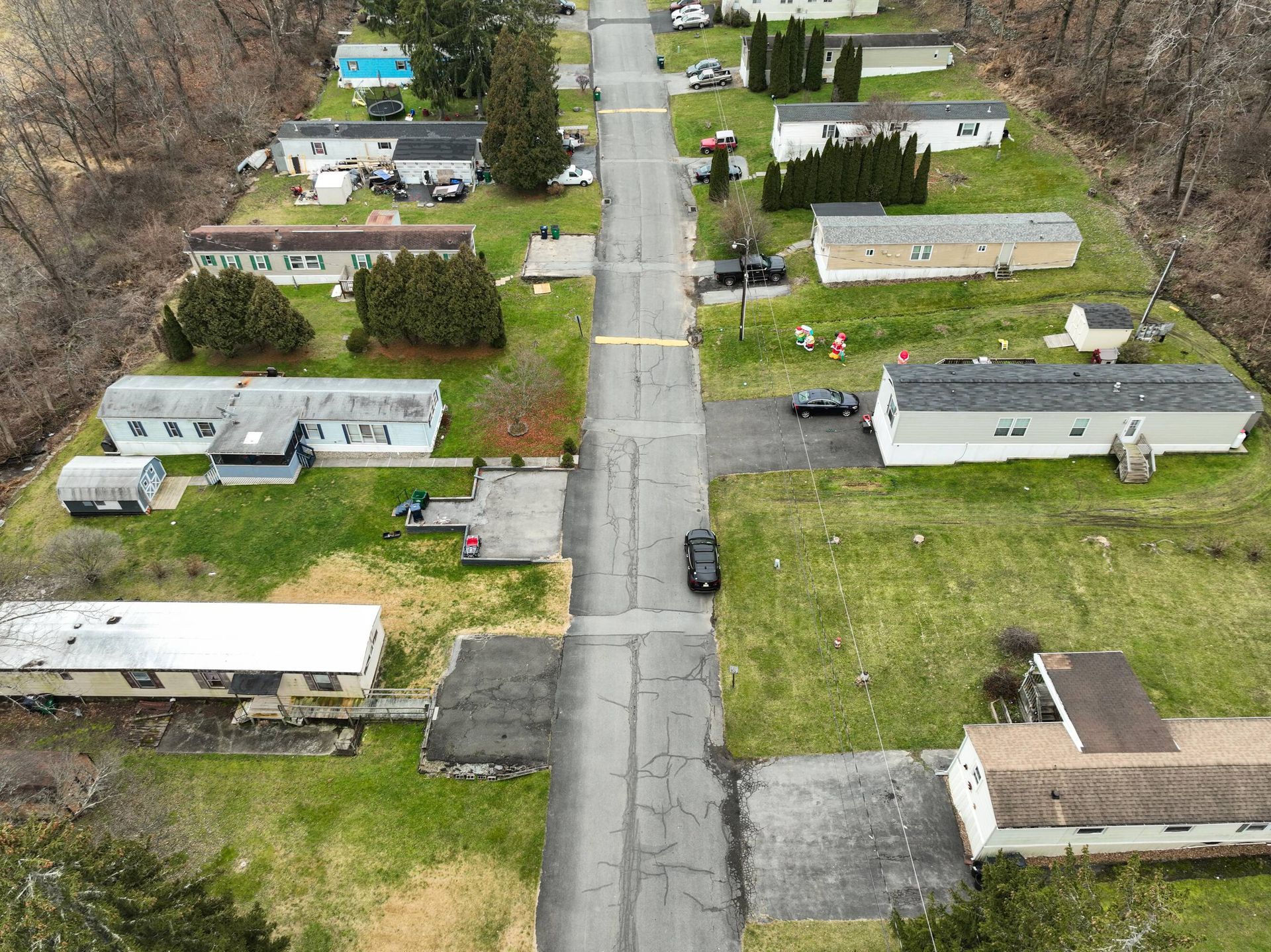An aerial view of a mobile home park with a road going through it.
