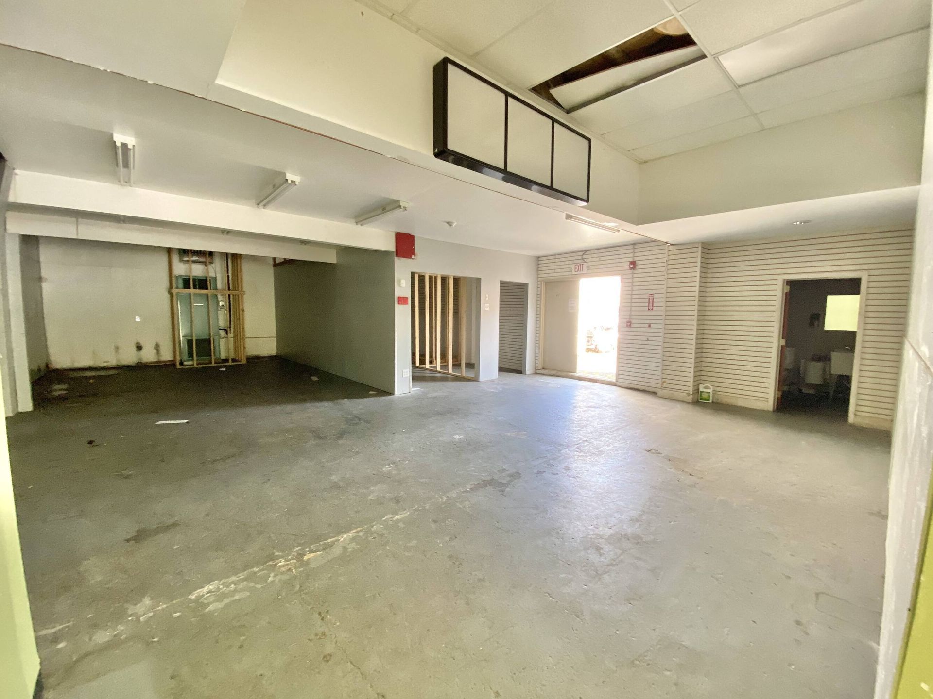 A large empty room with concrete floors and white walls.