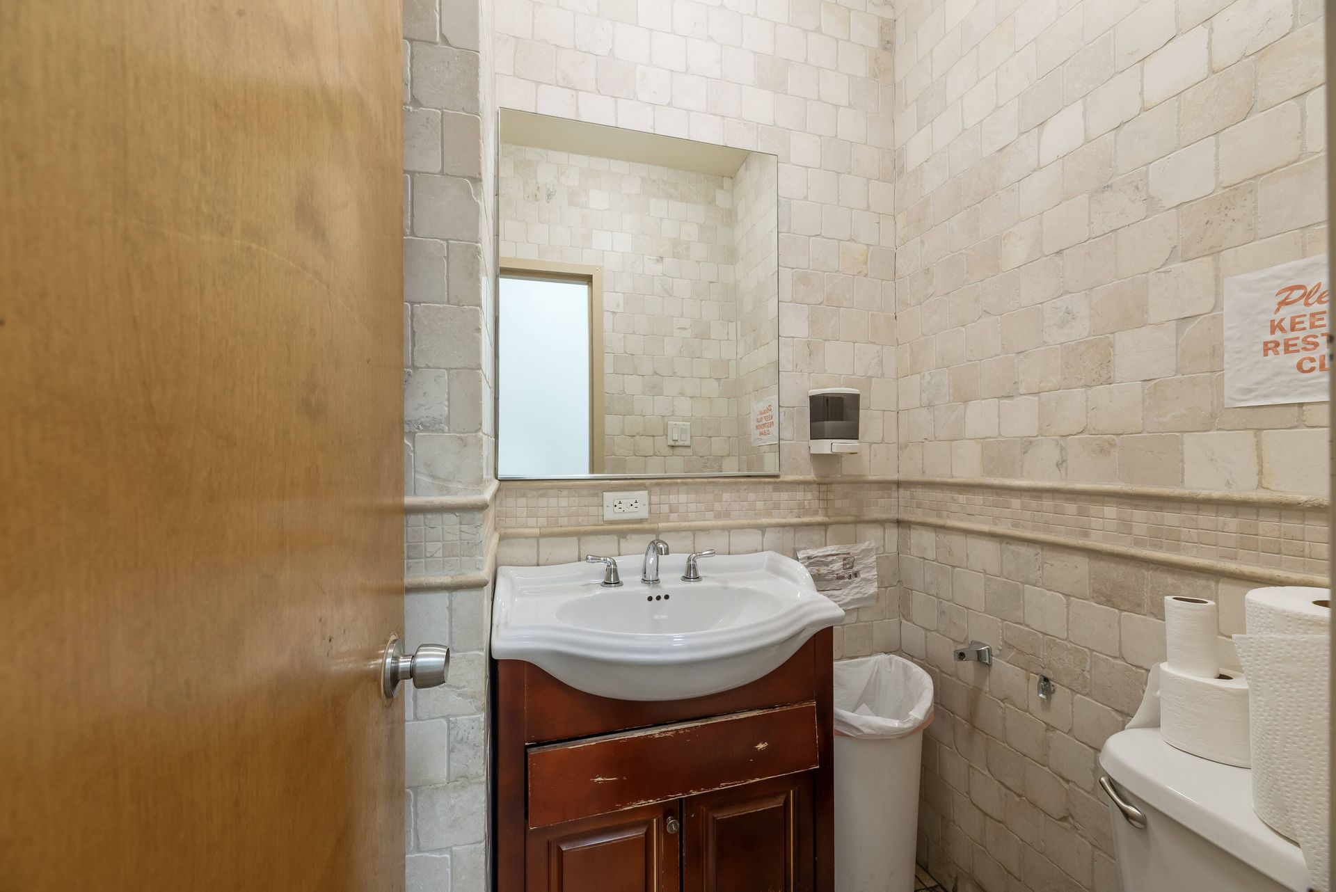 A bathroom with a sink , toilet and mirror.