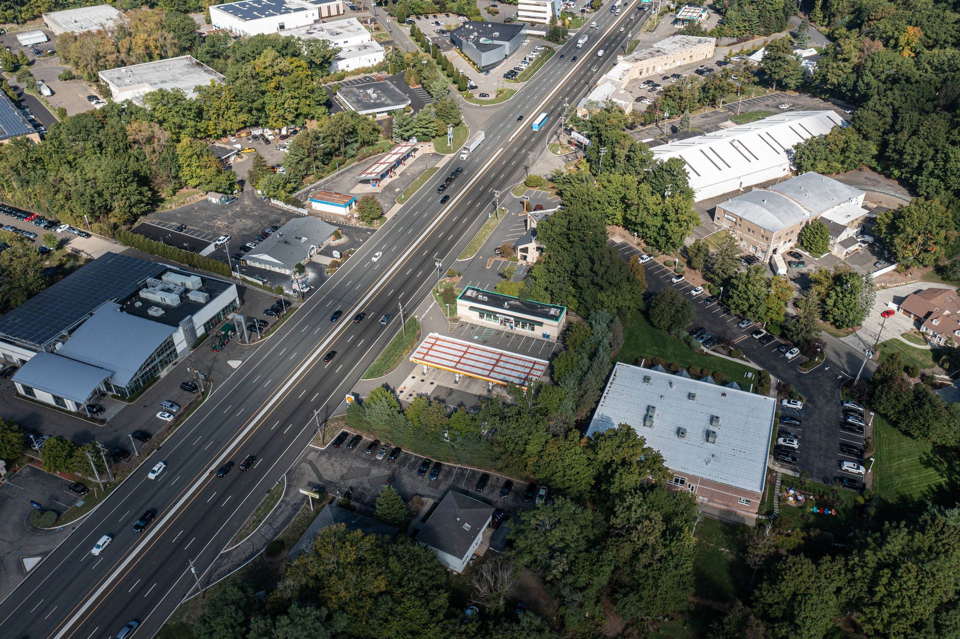 An aerial view of a highway surrounded by trees and buildings