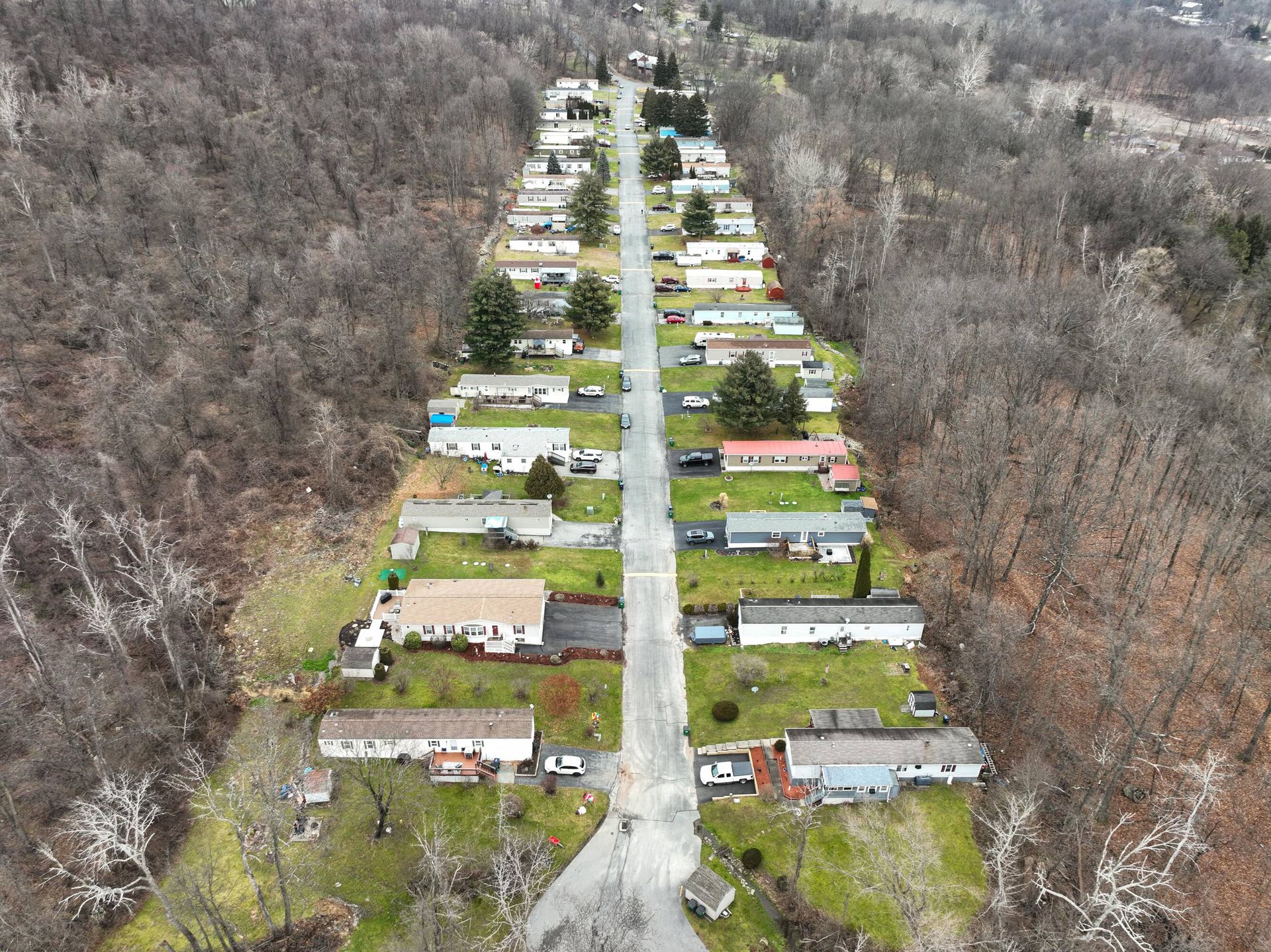 An aerial view of a mobile home park surrounded by trees.