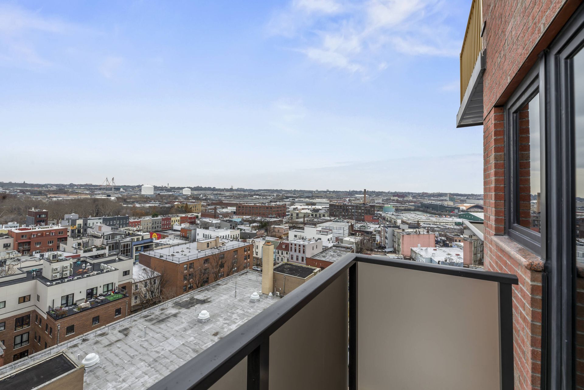A balcony with a view of a city from a brick building.