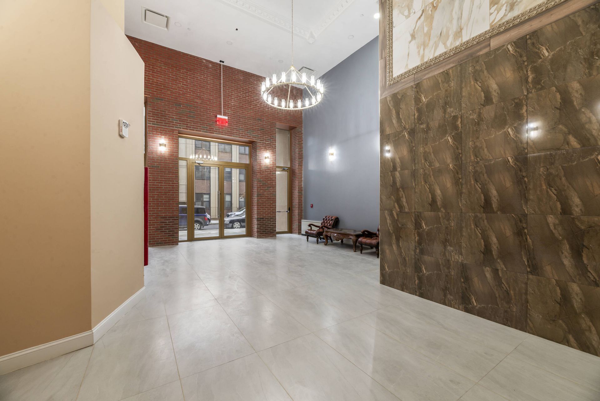 A large empty lobby with a chandelier hanging from the ceiling.