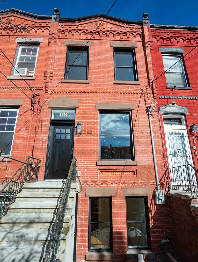 A red brick building with stairs leading up to it.