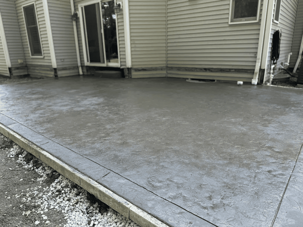 A concrete patio is being built in front of a house.
