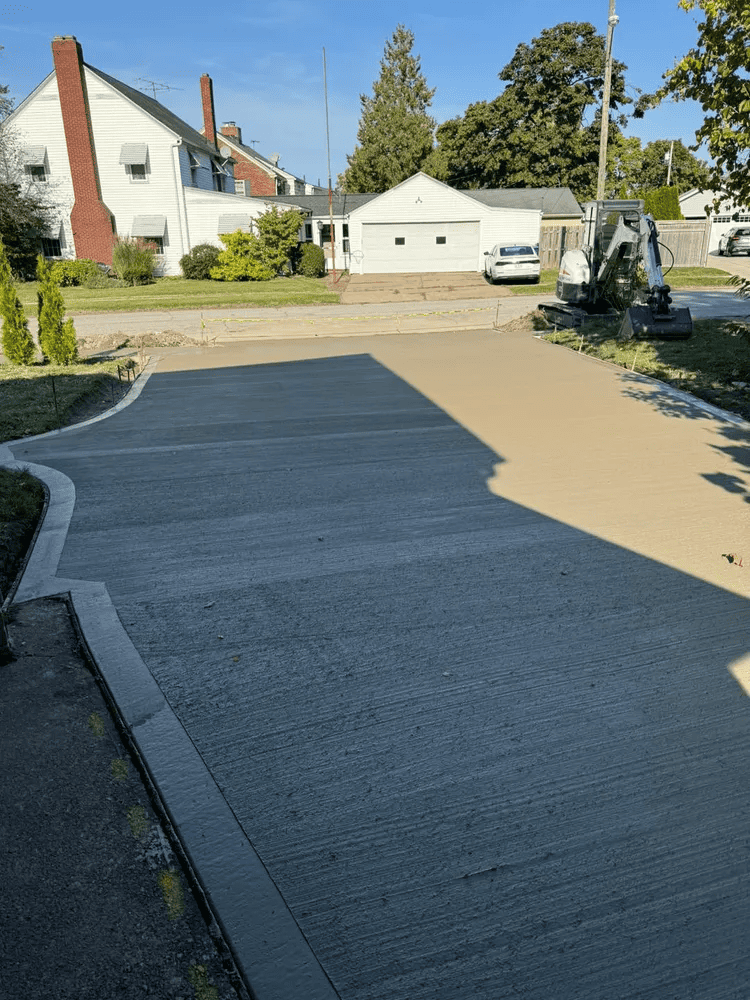 A concrete driveway is being built in front of a house.