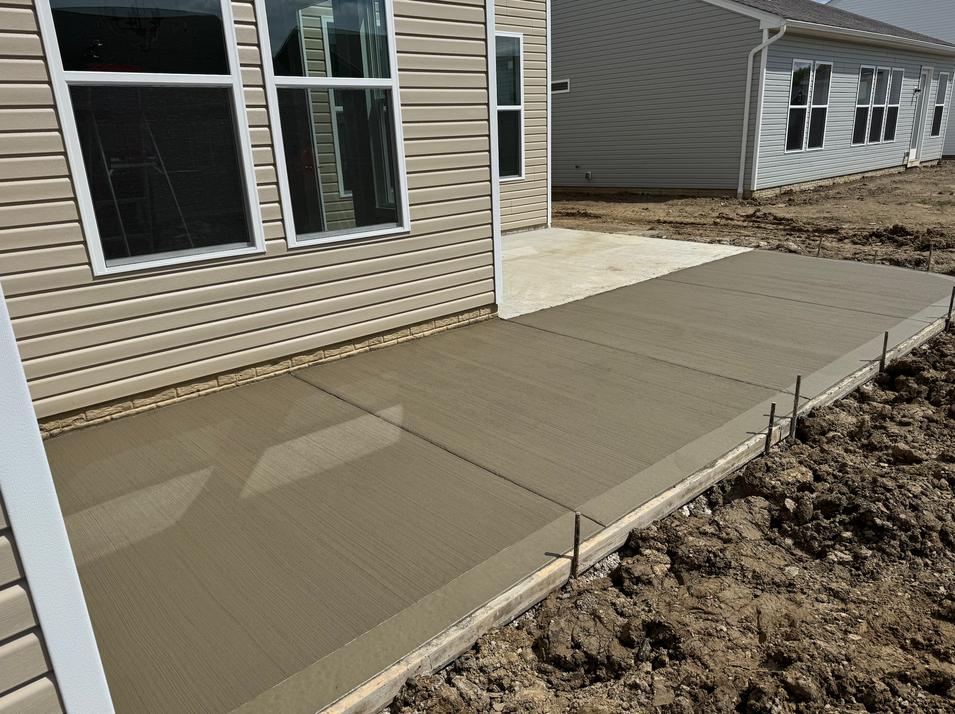 A concrete walkway is being built in front of a house