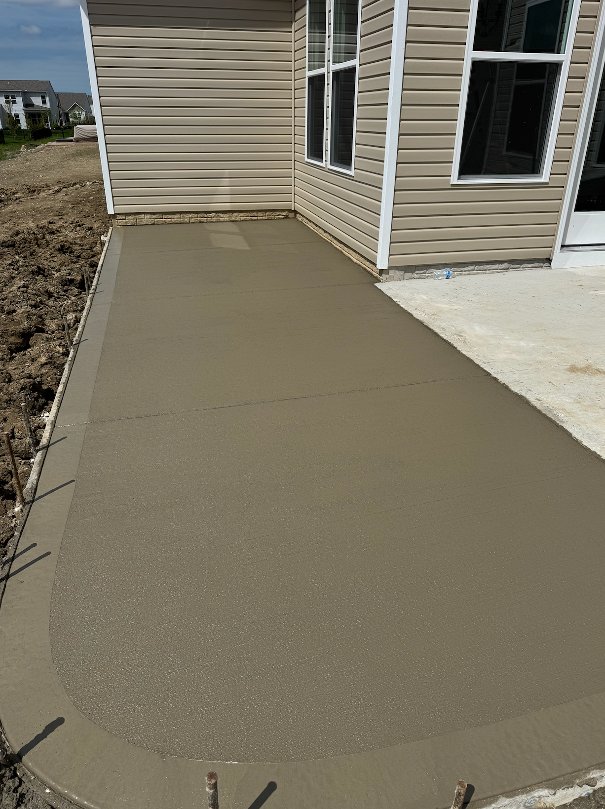 A concrete walkway is being built in front of a house.