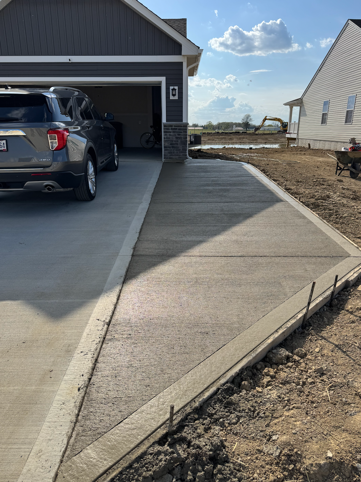 A car is parked in a driveway next to a garage.