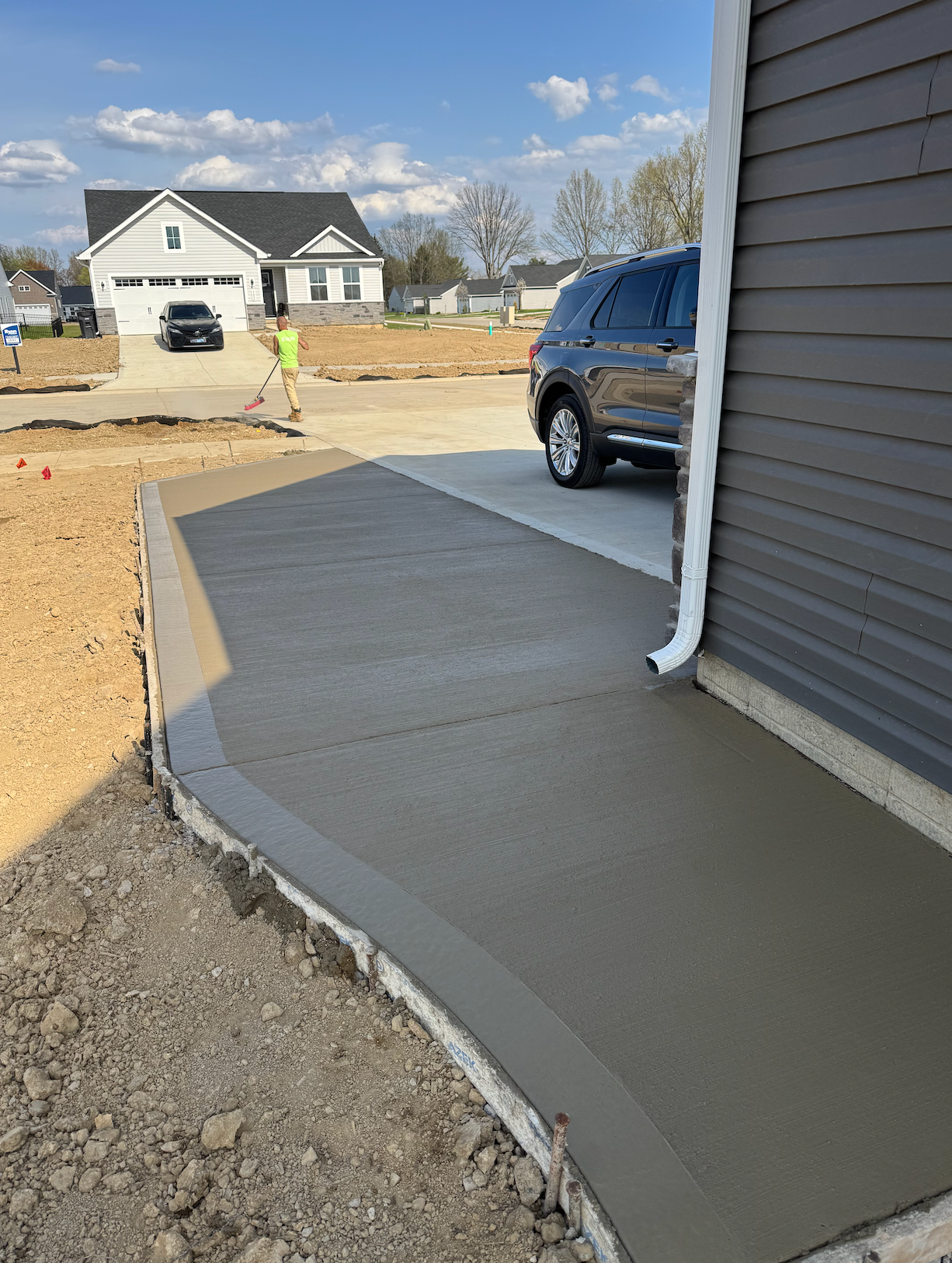 A car is parked in a driveway next to a house.