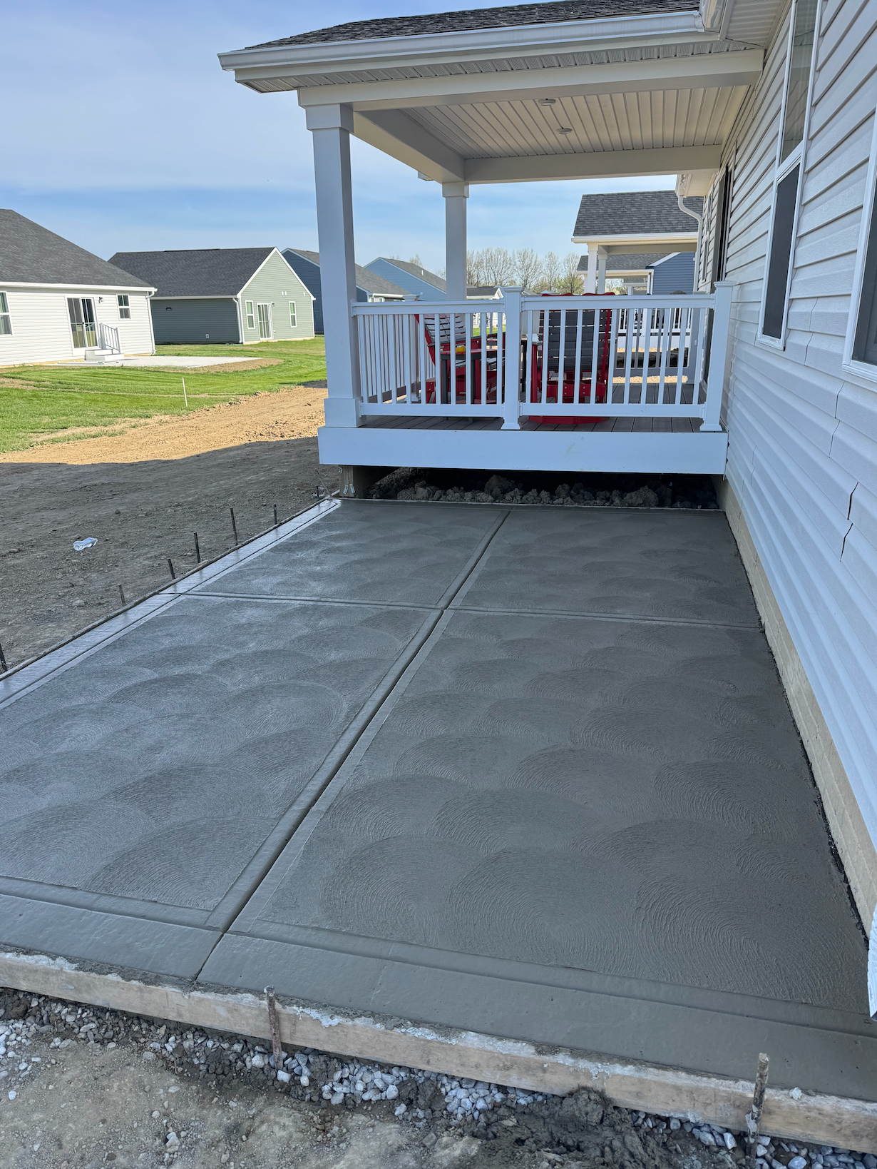 A concrete porch is being built on the side of a house.