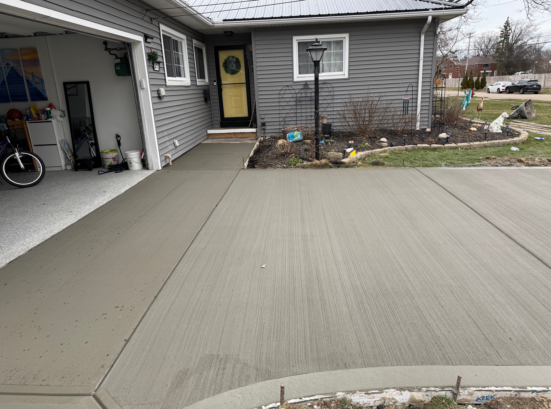 A concrete driveway is being built in front of a house.