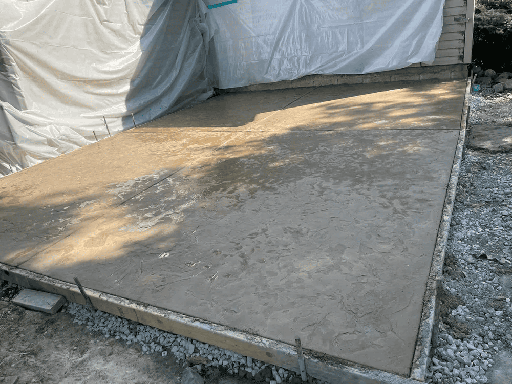 A concrete floor is being built in front of a house.