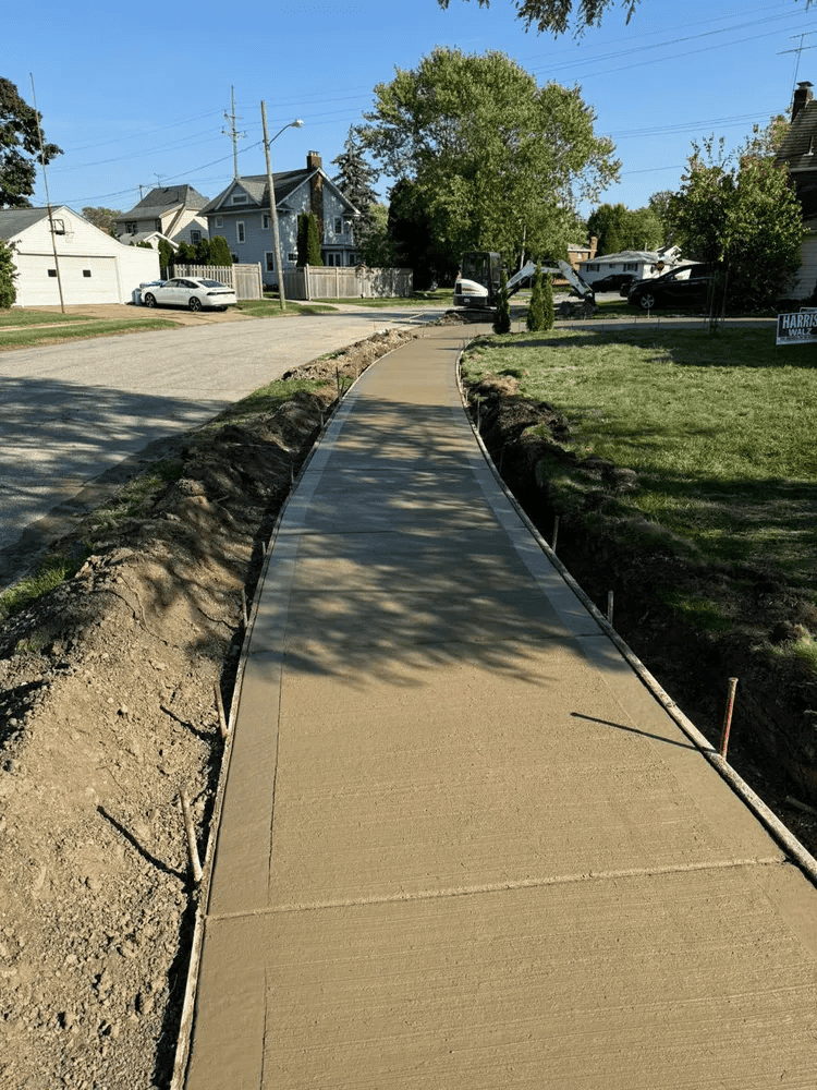 A concrete sidewalk is being built on the side of a road.
