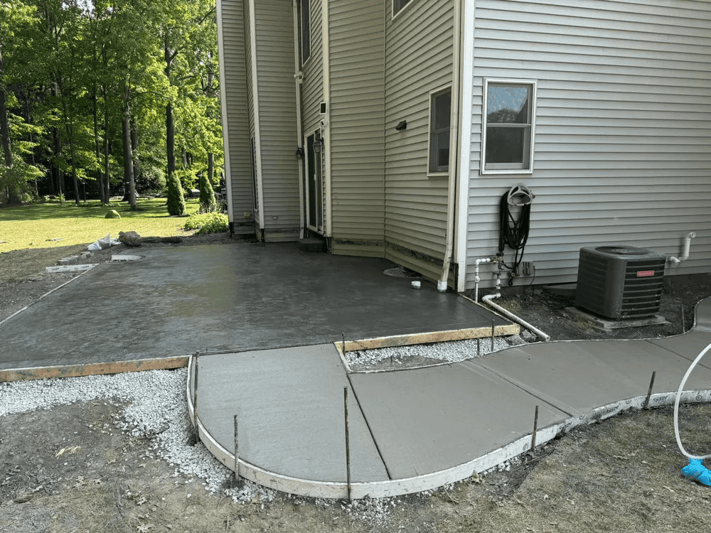 A concrete walkway is being built in front of a house.