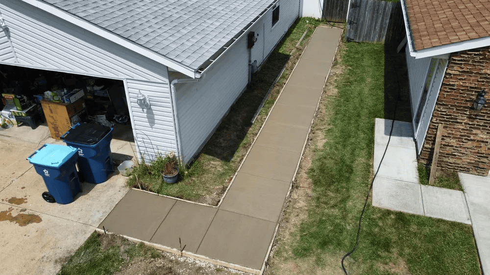 An aerial view of a sidewalk leading to a house.
