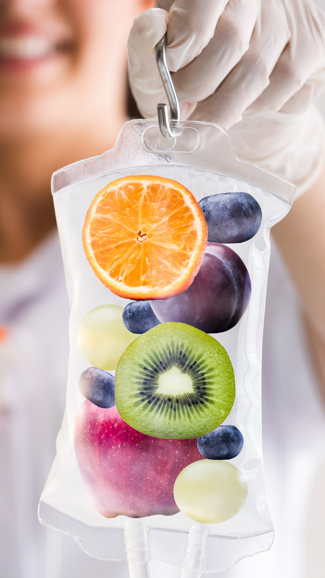 Person holding IV bag filled with fruit: orange, kiwi, apple, plum, and blueberries.