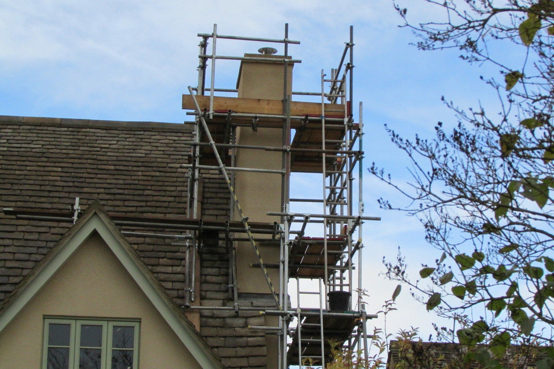 A chimney is being built on the side of a house