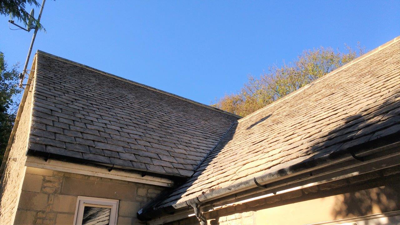 A roof of a house with a blue sky in the background.