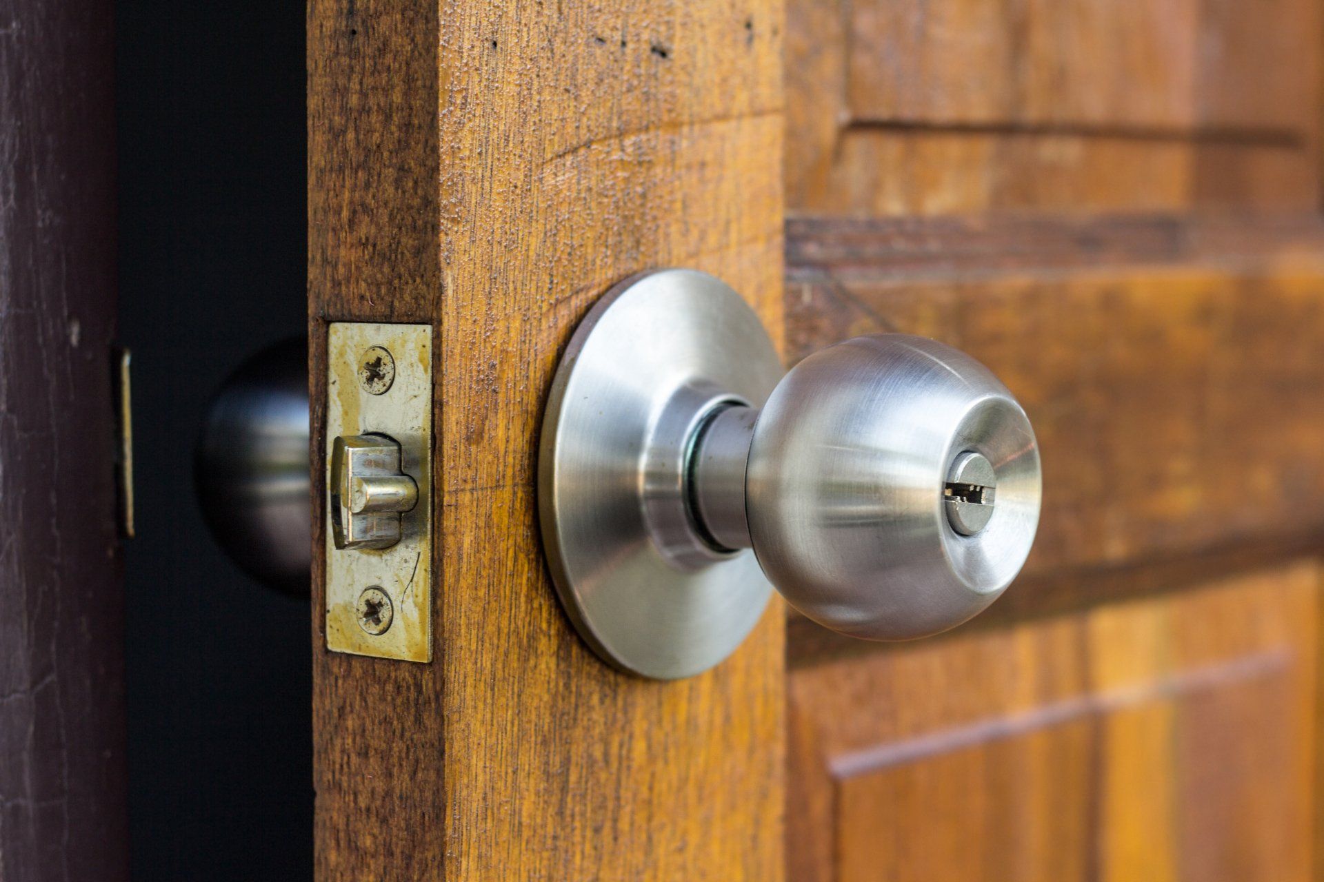 A close up of a door knob on a wooden door.