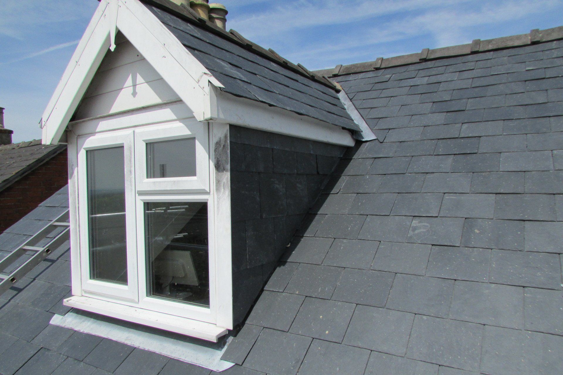 A roof with a window on it and a slate roof