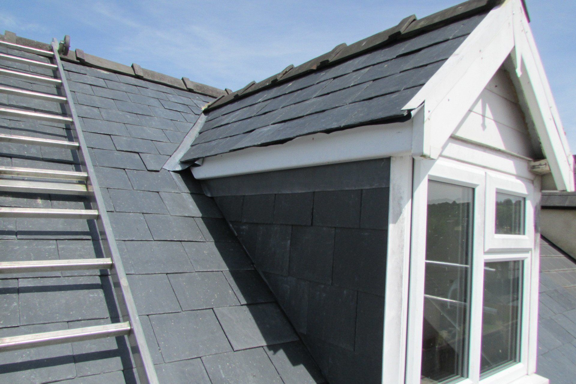 A roof with a window and a ladder on it