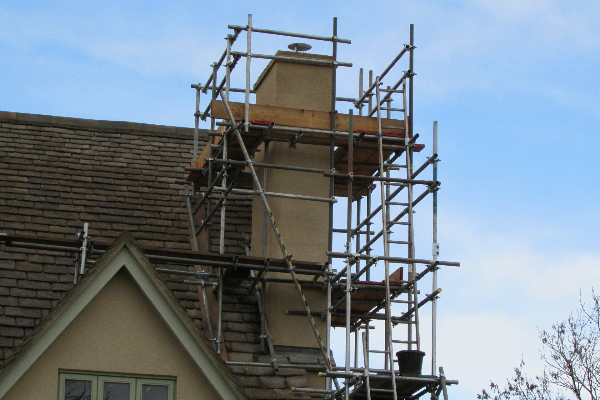A chimney is being worked on with scaffolding around it