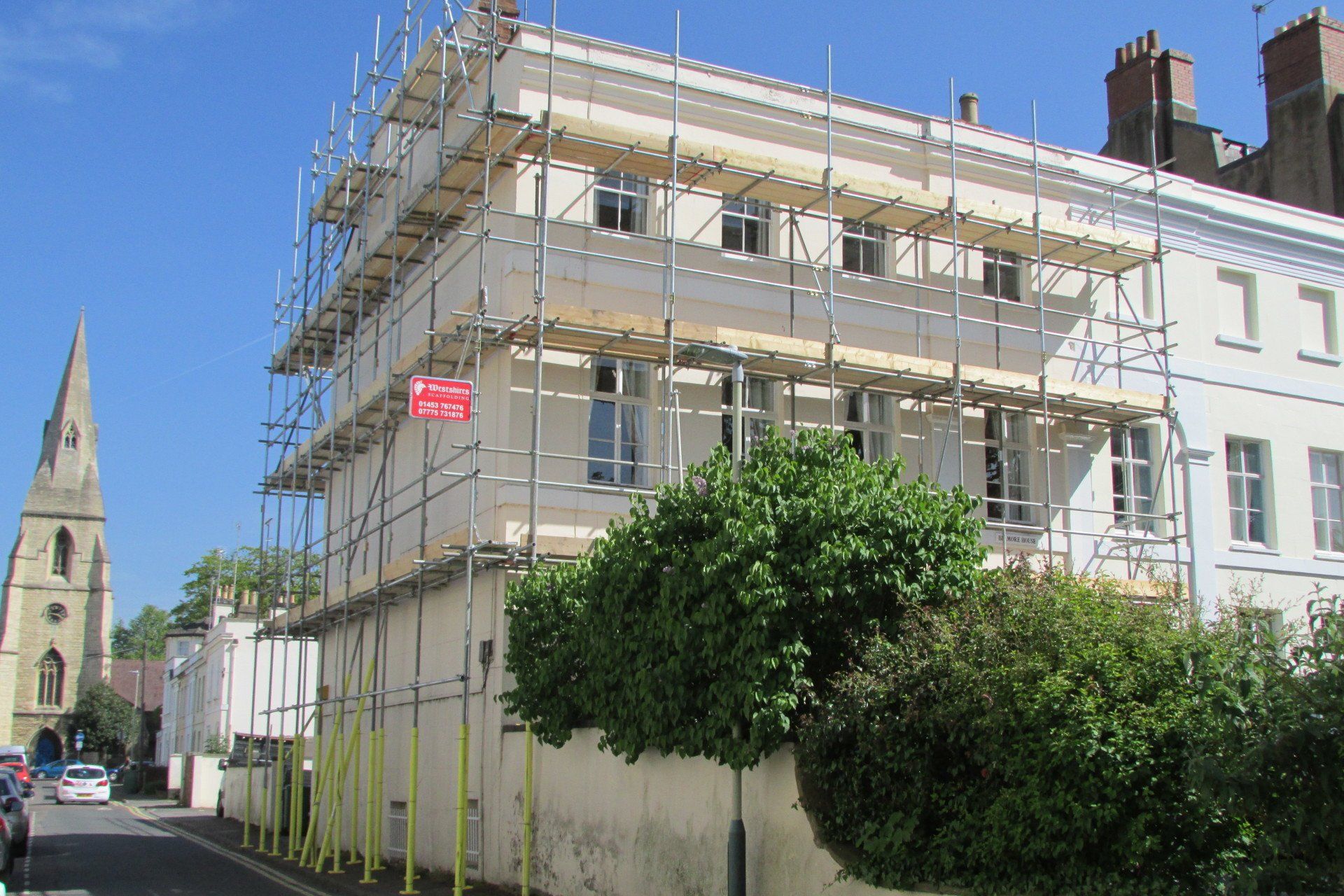 A building with scaffolding on it and a sign that says ' for sale ' on it