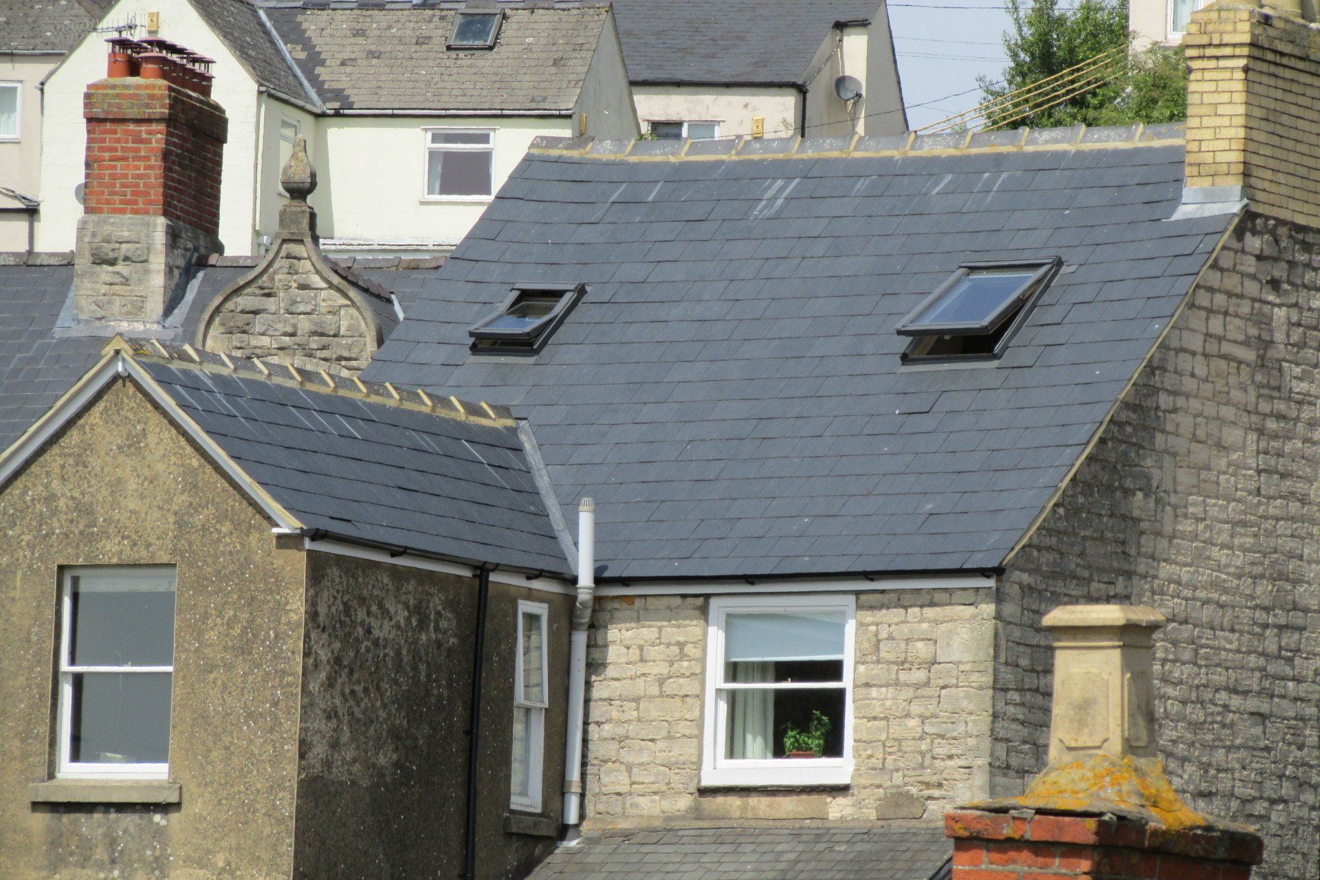 A row of houses with slate roofs and chimneys