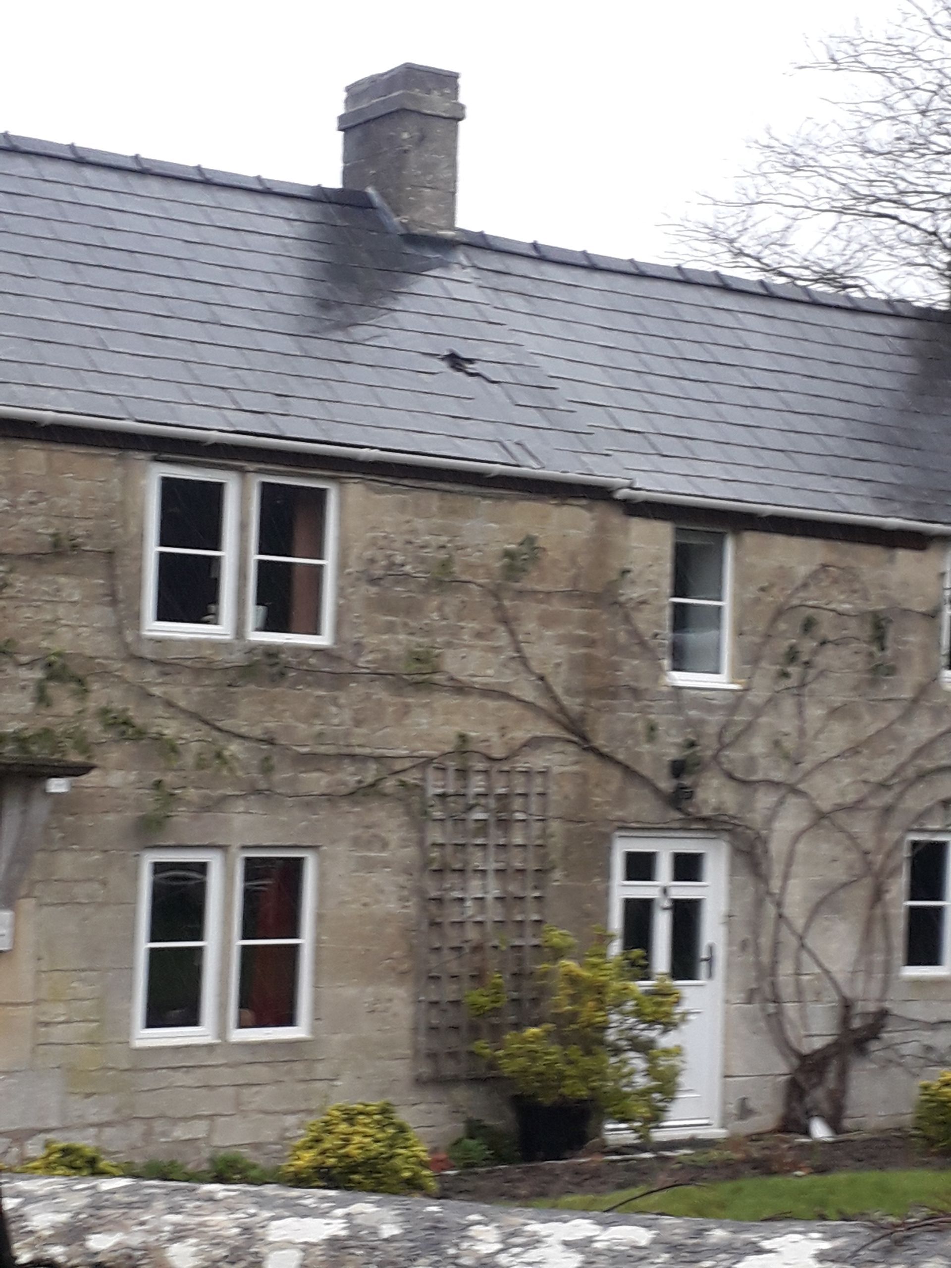 A stone house with a chimney on top of it
