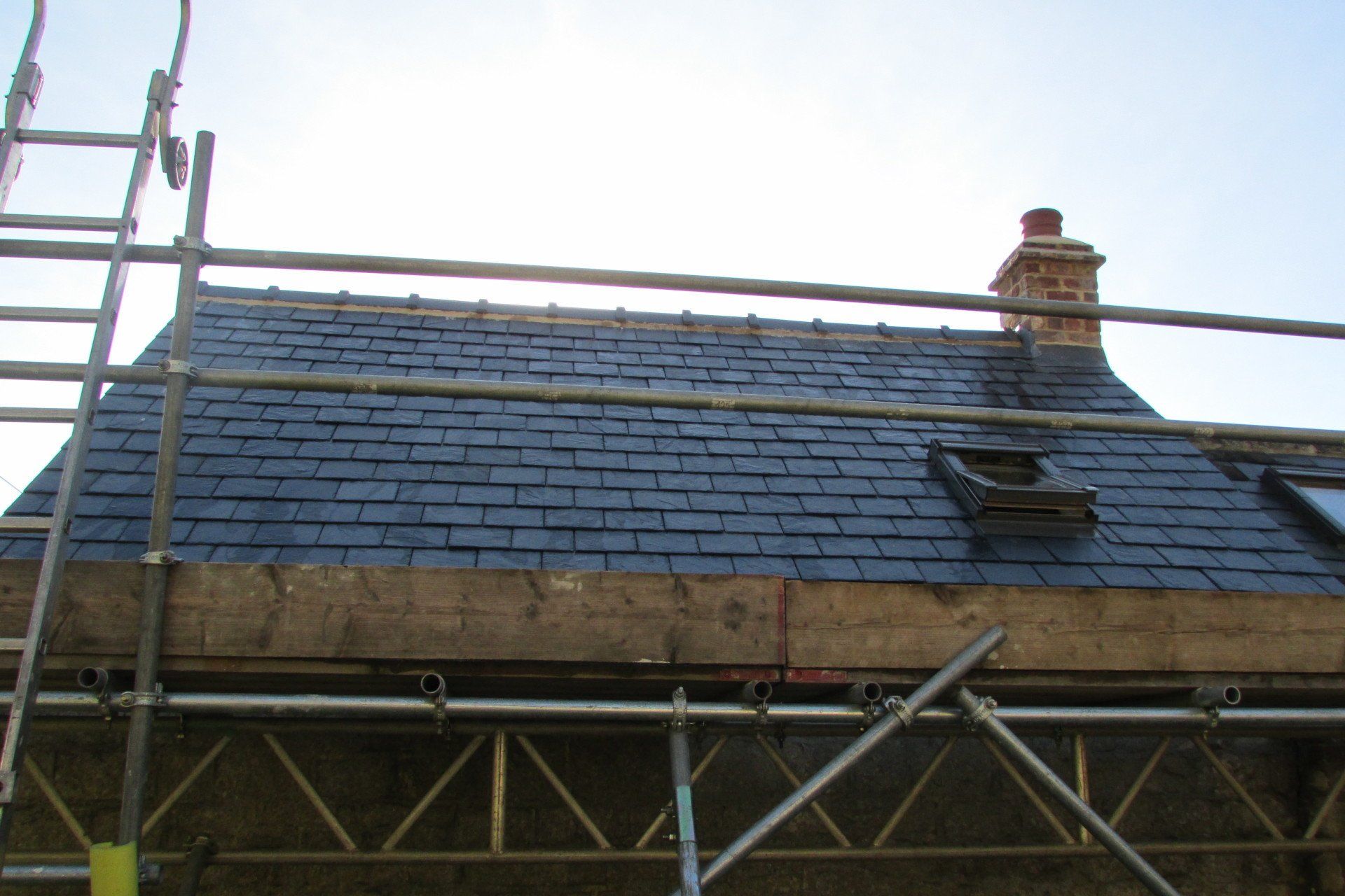 A roof with scaffolding and a chimney on it