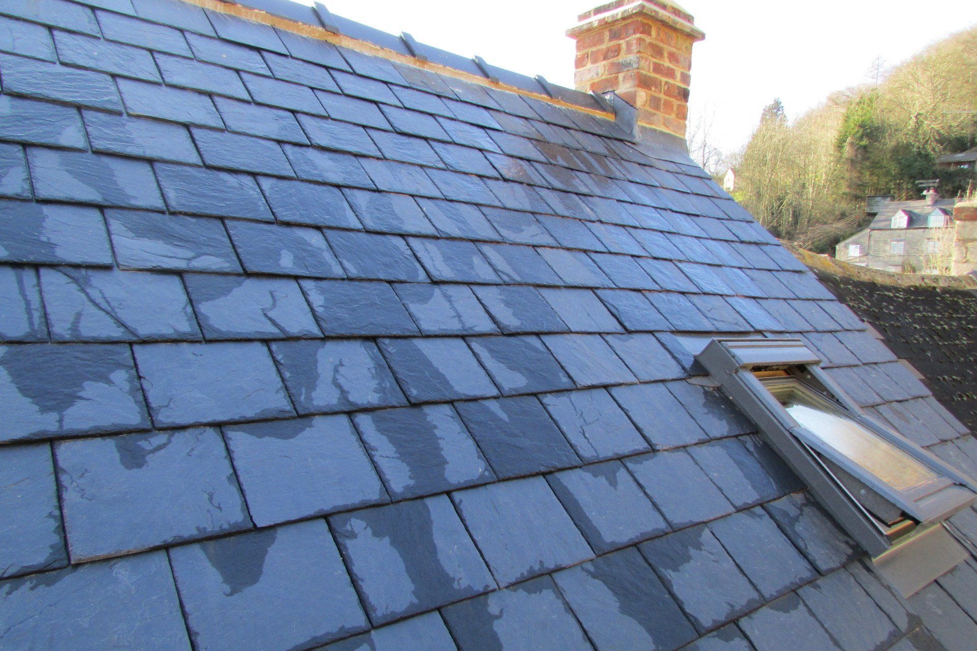 A roof with slate tiles and a skylight on it