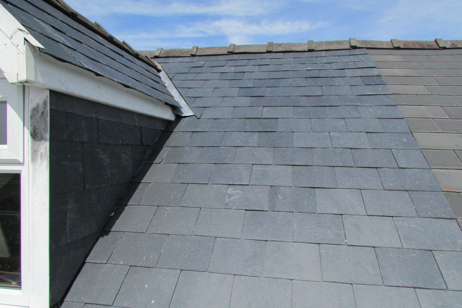 A roof with slate tiles and a window on it