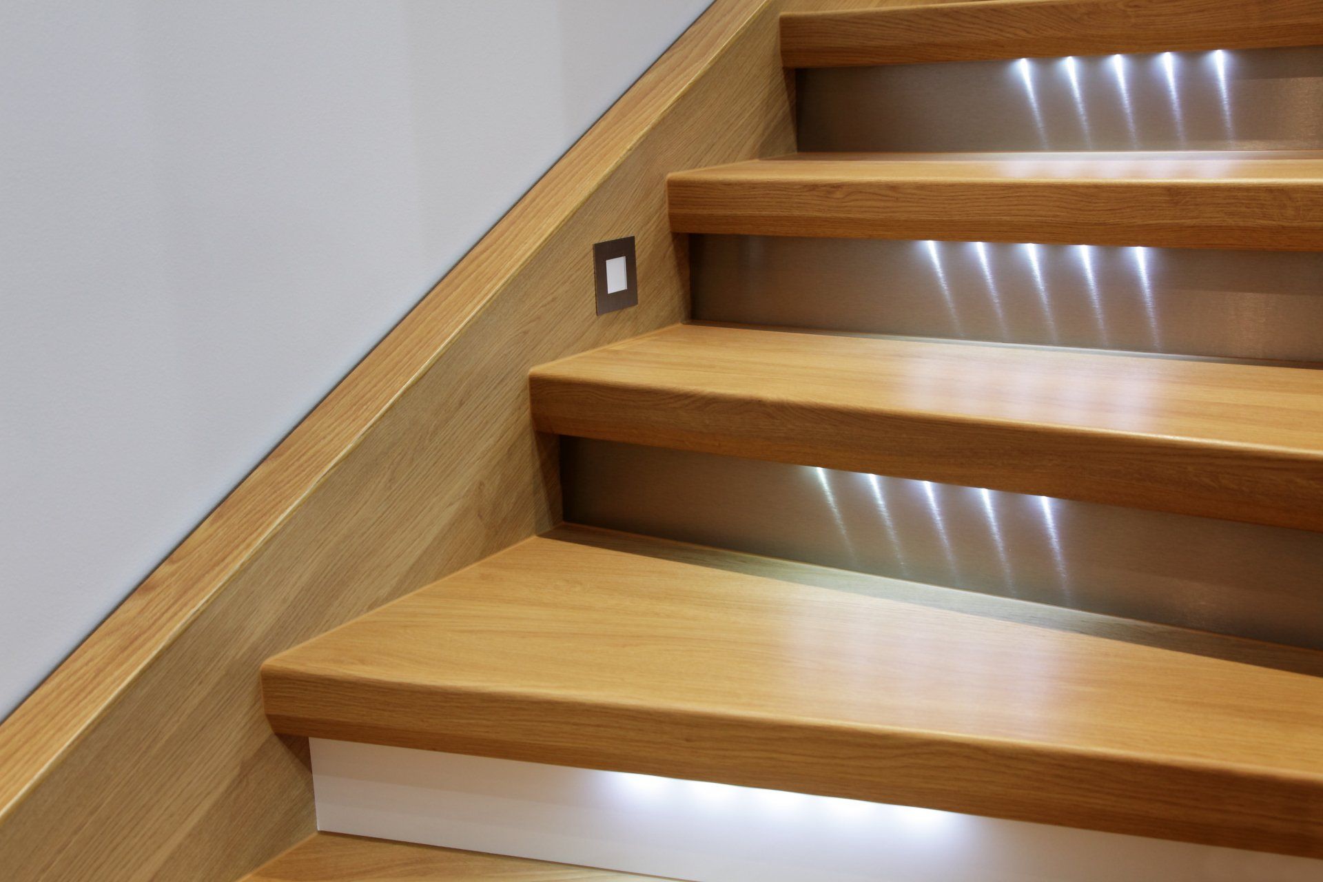 A set of wooden stairs with lights on the steps