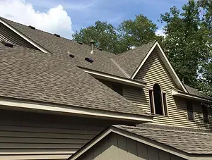 A large house with a roof that is covered in shingles.