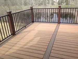 A wooden deck with a metal railing overlooking a body of water.