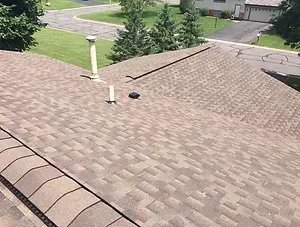 A roof with a chimney on top of it in a residential area.