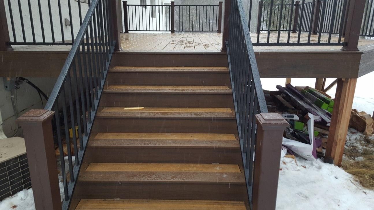 A set of stairs leading up to a deck with a railing.