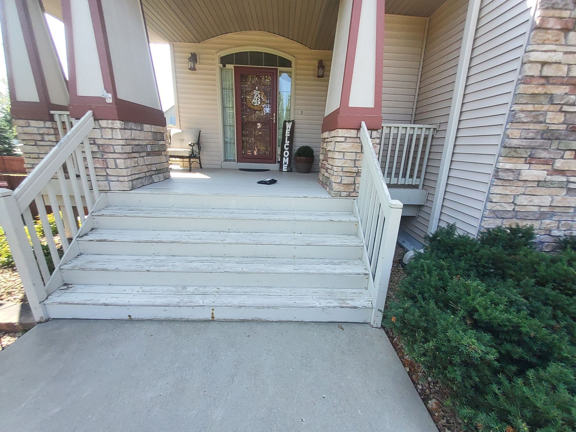 A white staircase leading up to the front door of a house.