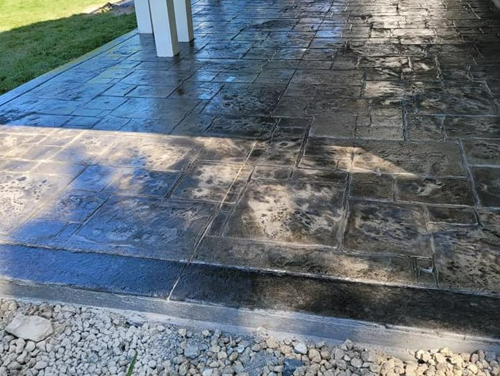 A concrete walkway with steps leading up to a porch.