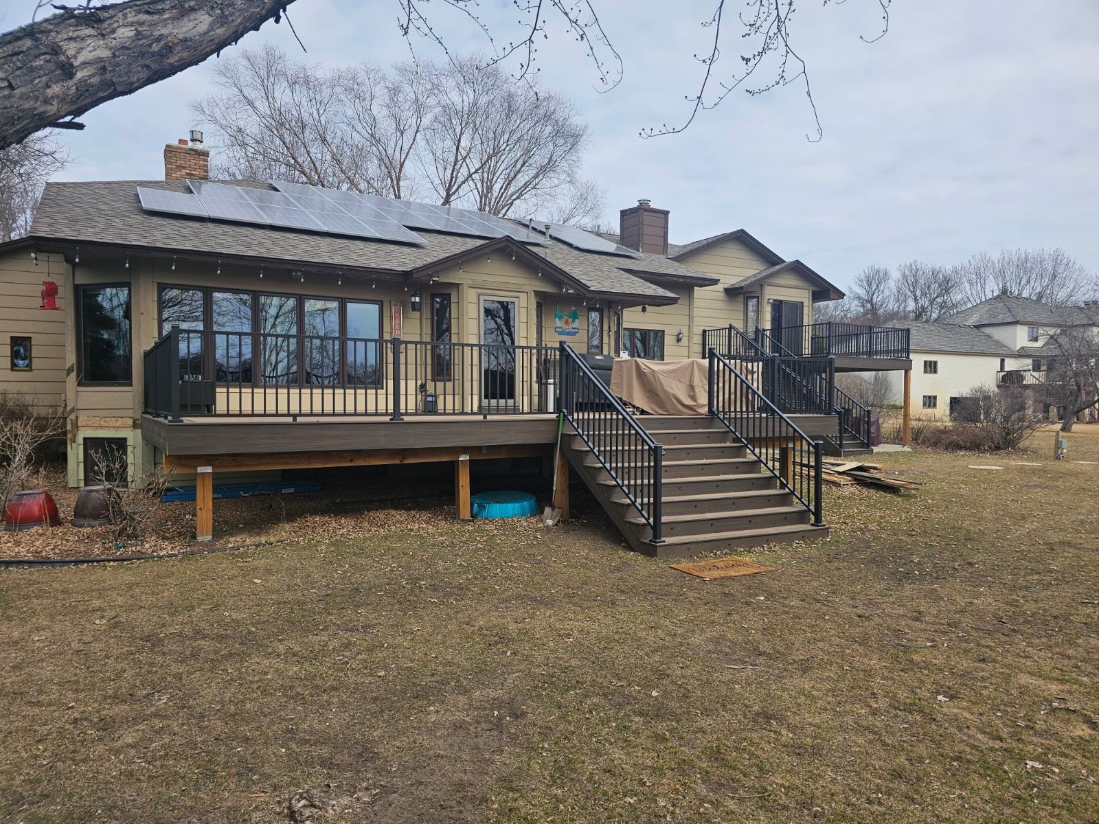 The back of a house with a large deck and stairs.