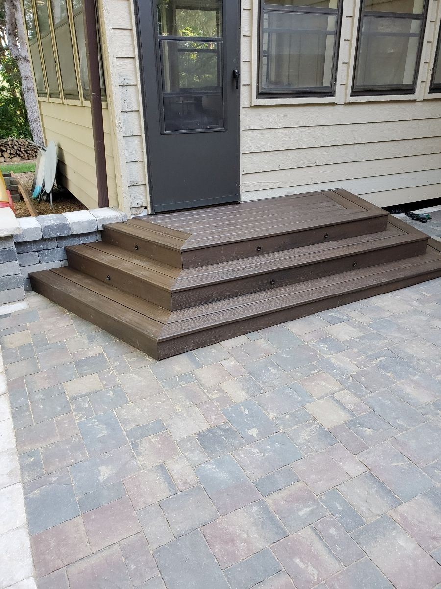 A set of stairs leading up to a house on a brick patio.